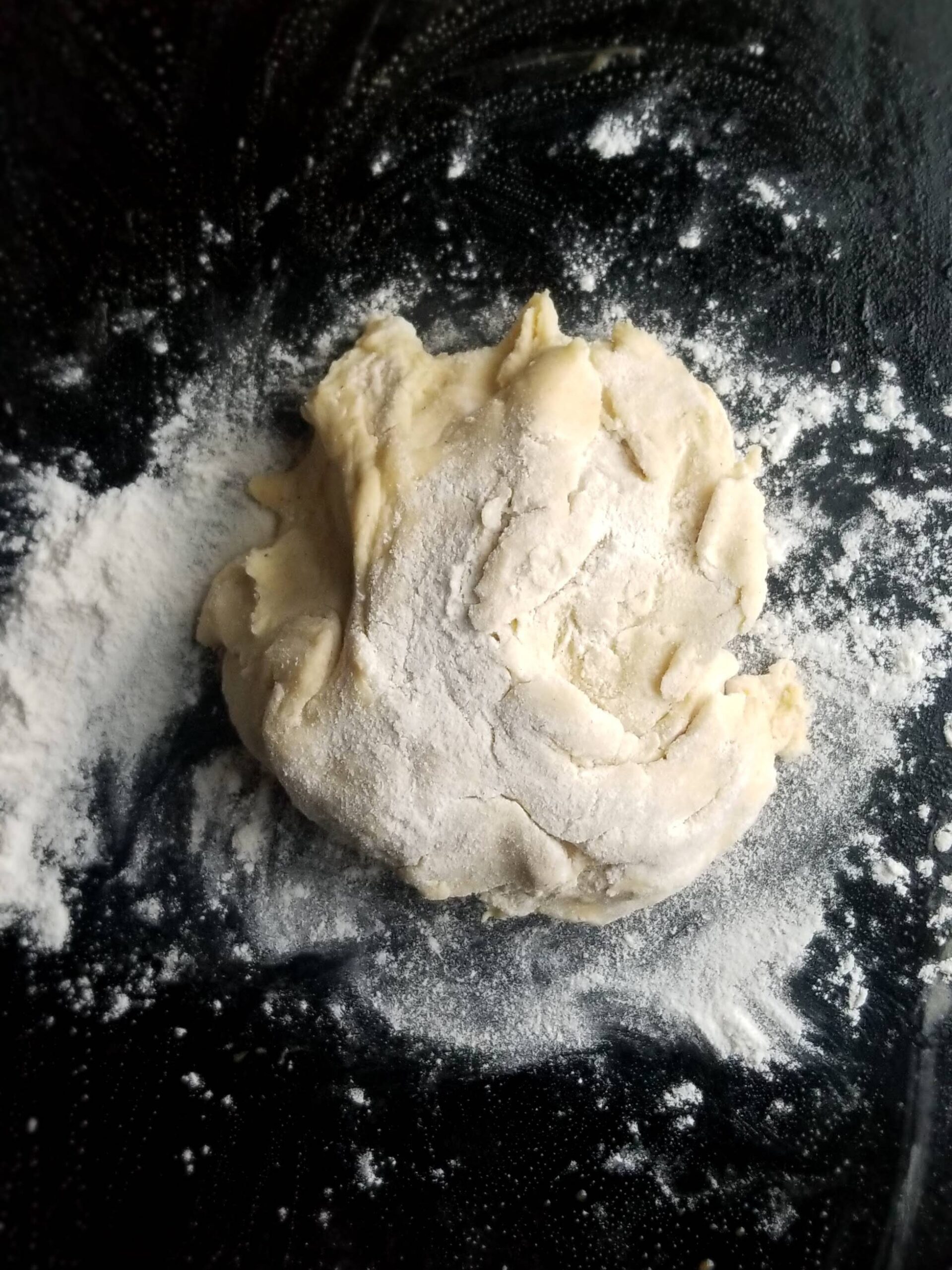 Rolled gluten free pizza dough on baking sheet before baking
