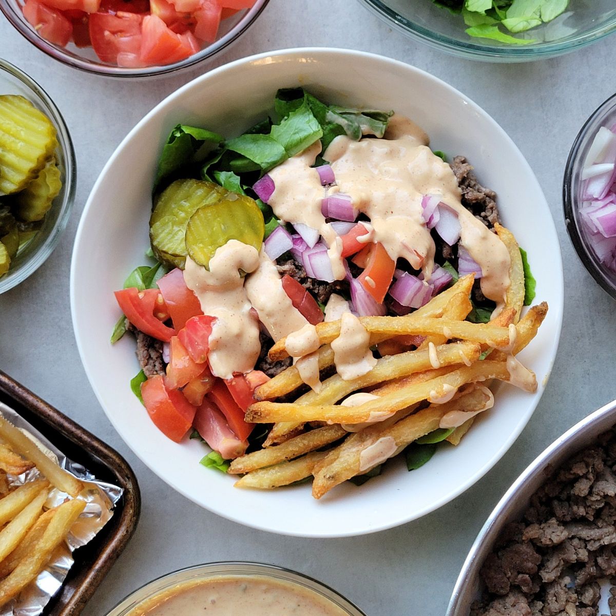 Overhead view of Big Mac burger bowls with lettuce, beef, pickles, fries and special sauce