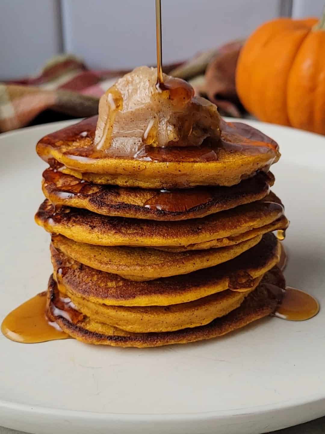 recipe for gluten free pumpkin pancakes topped with homemade cinnamon butter and pure maple syrup