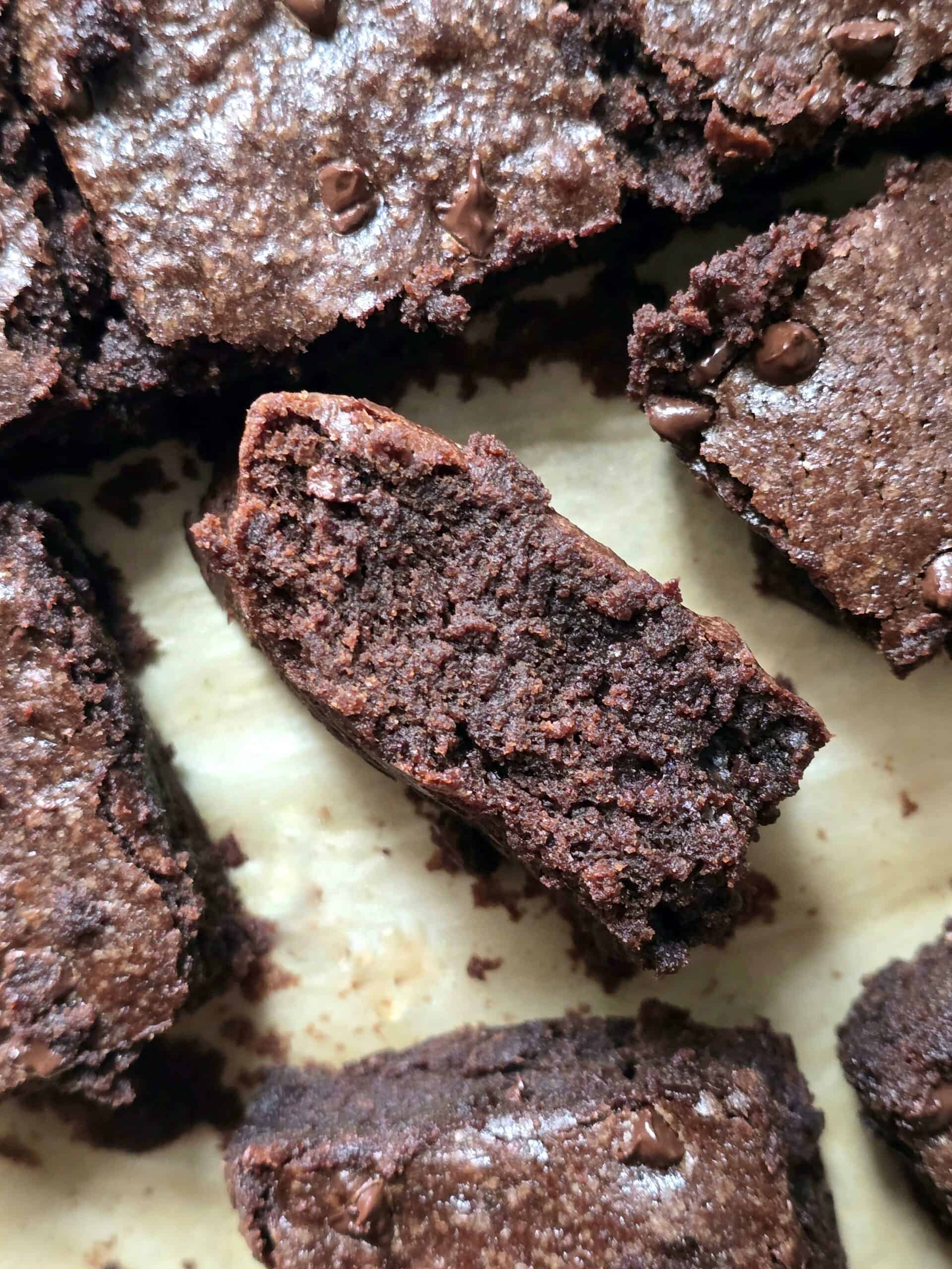 Homemade gluten free brownies with a rich fudgy texture cut into squares on parchment paper