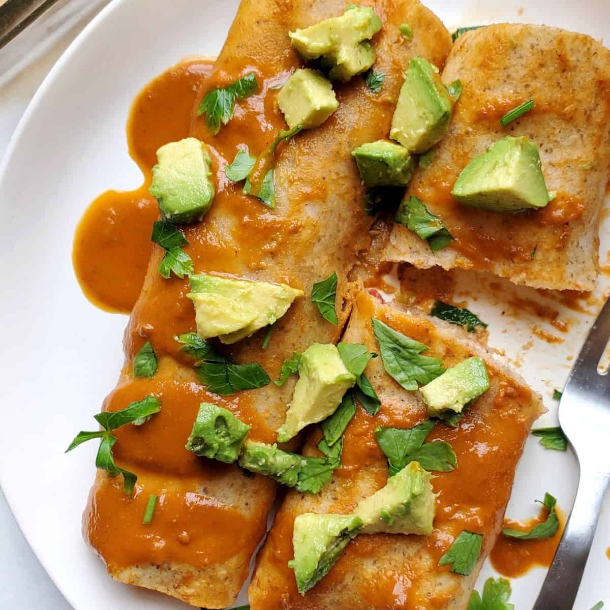 Gluten free beef enchiladas made with ground beef, refried beans, and melted cheese baked in enchilada sauce.