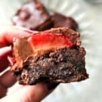 Close-up of chocolate ganache over strawberries on gluten free brownies