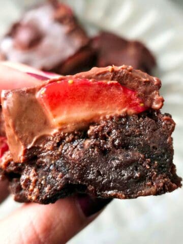 Close-up of chocolate ganache over strawberries on gluten free brownies