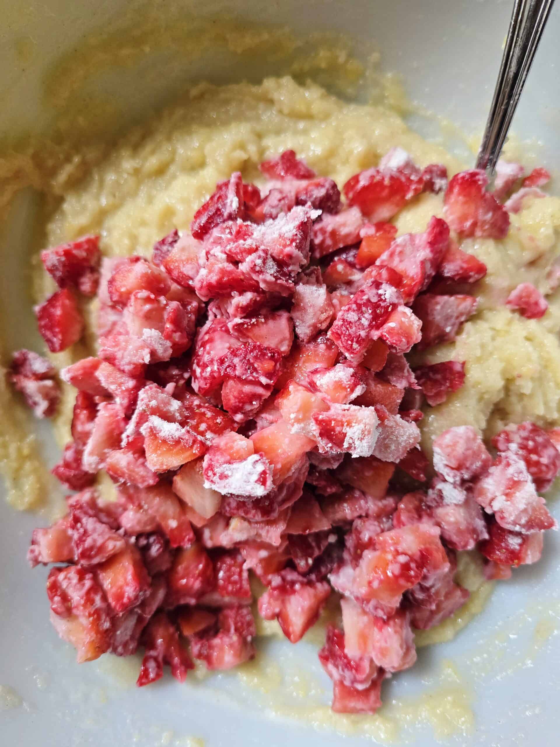 Gluten free strawberry bread batter with fresh diced strawberries poured into a loaf pan before baking.
