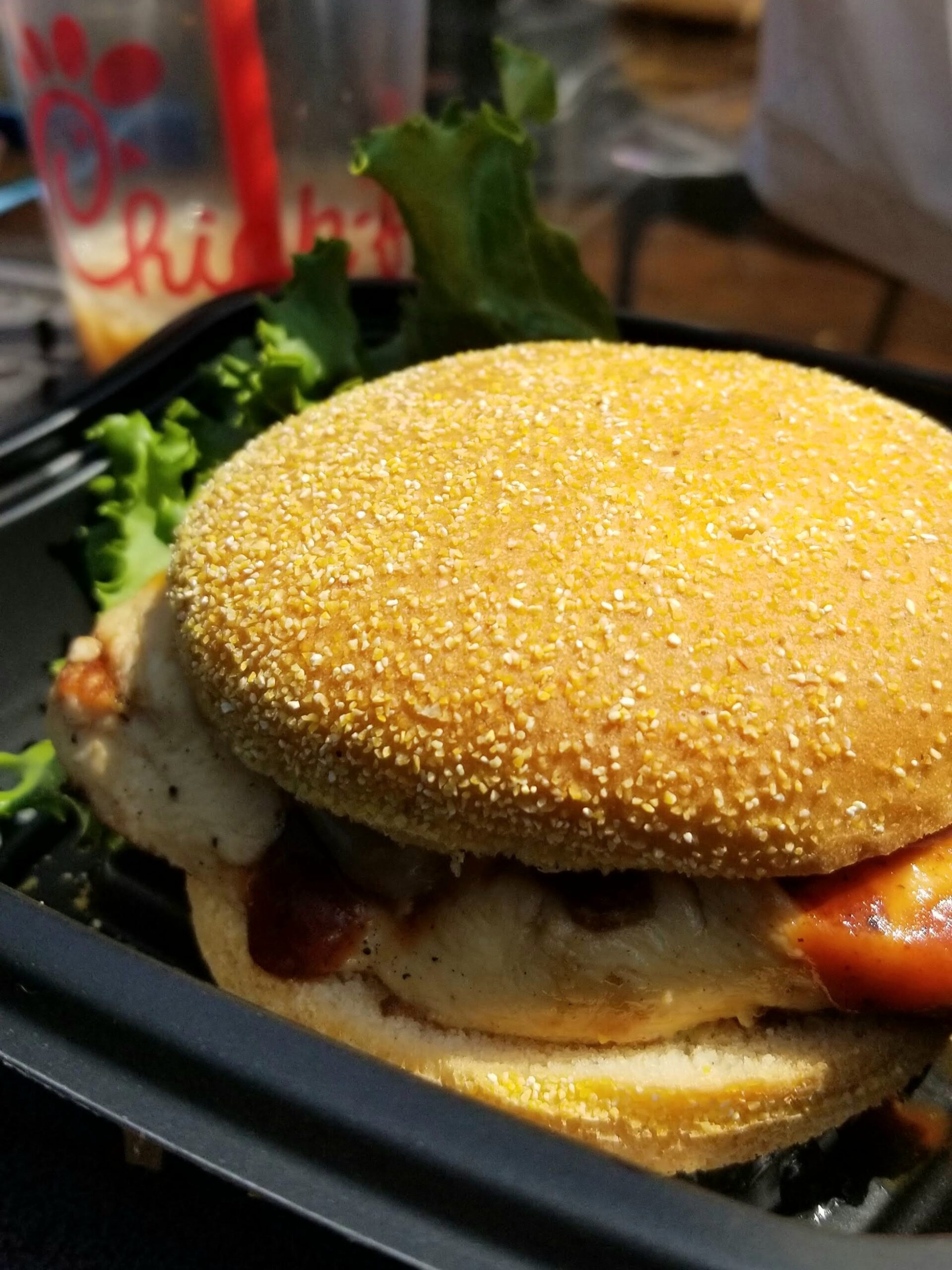 Gluten-free Chick-fil-A grilled chicken sandwich with gluten-free bun, lettuce and tomato