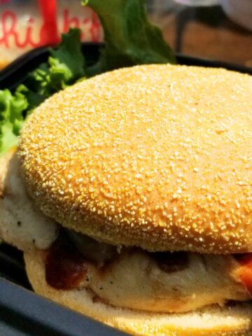 Gluten-free Chick-fil-A grilled chicken sandwich served on a packaged gluten-free bun with lettuce and tomato