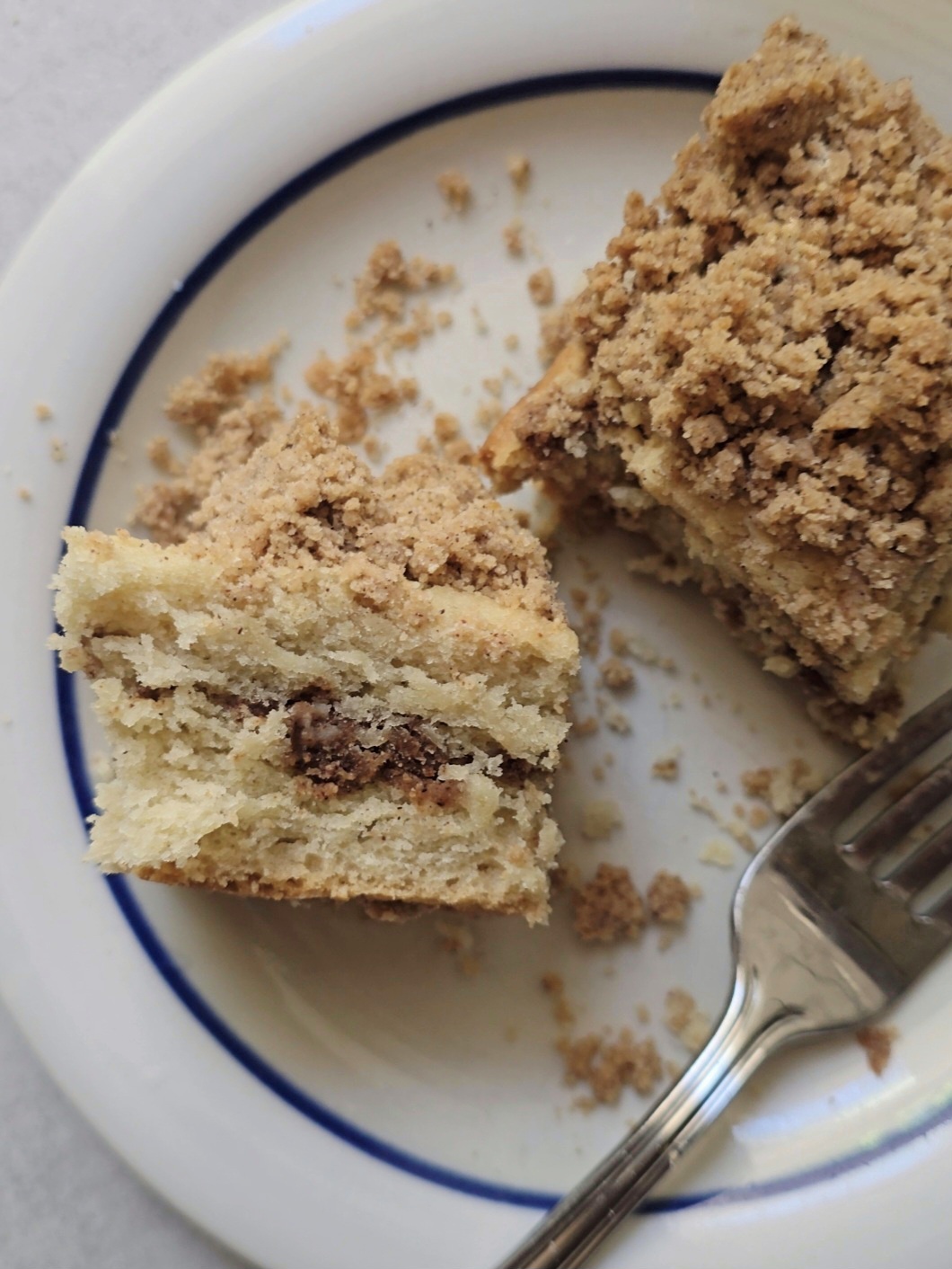 Slice of gluten free cinnamon swirl coffee cake showing soft fluffy texture and cinnamon layers