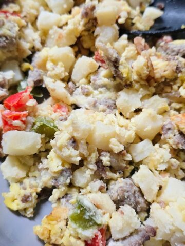 gluten free Sausage breakfast scramble with eggs, potatoes, peppers, and onions in a skillet