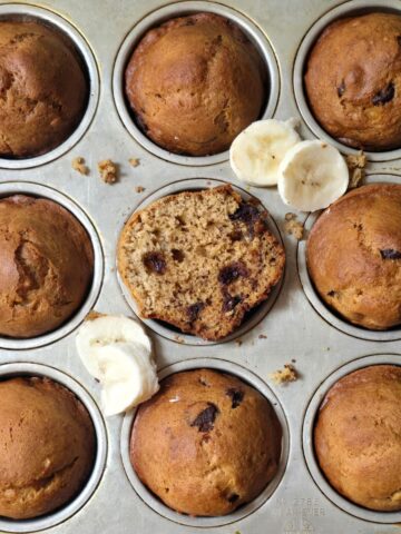 Close-up of a gluten free banana muffin broken in half showing its fluffy, tender crumb.