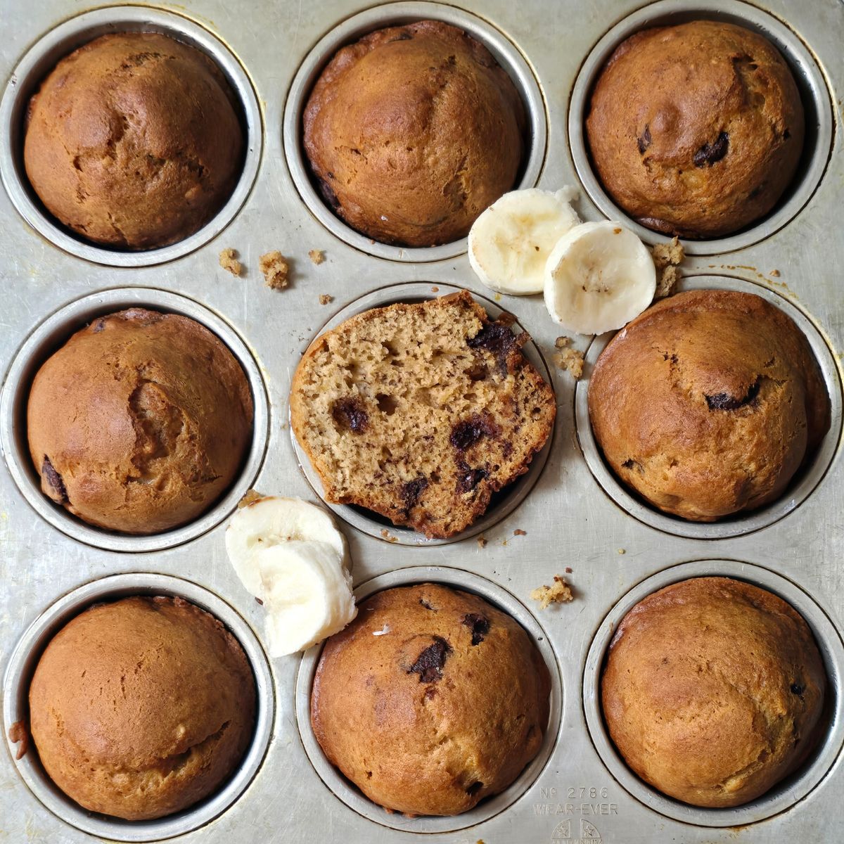 Close-up of a gluten free banana muffin broken in half showing its fluffy, tender crumb.