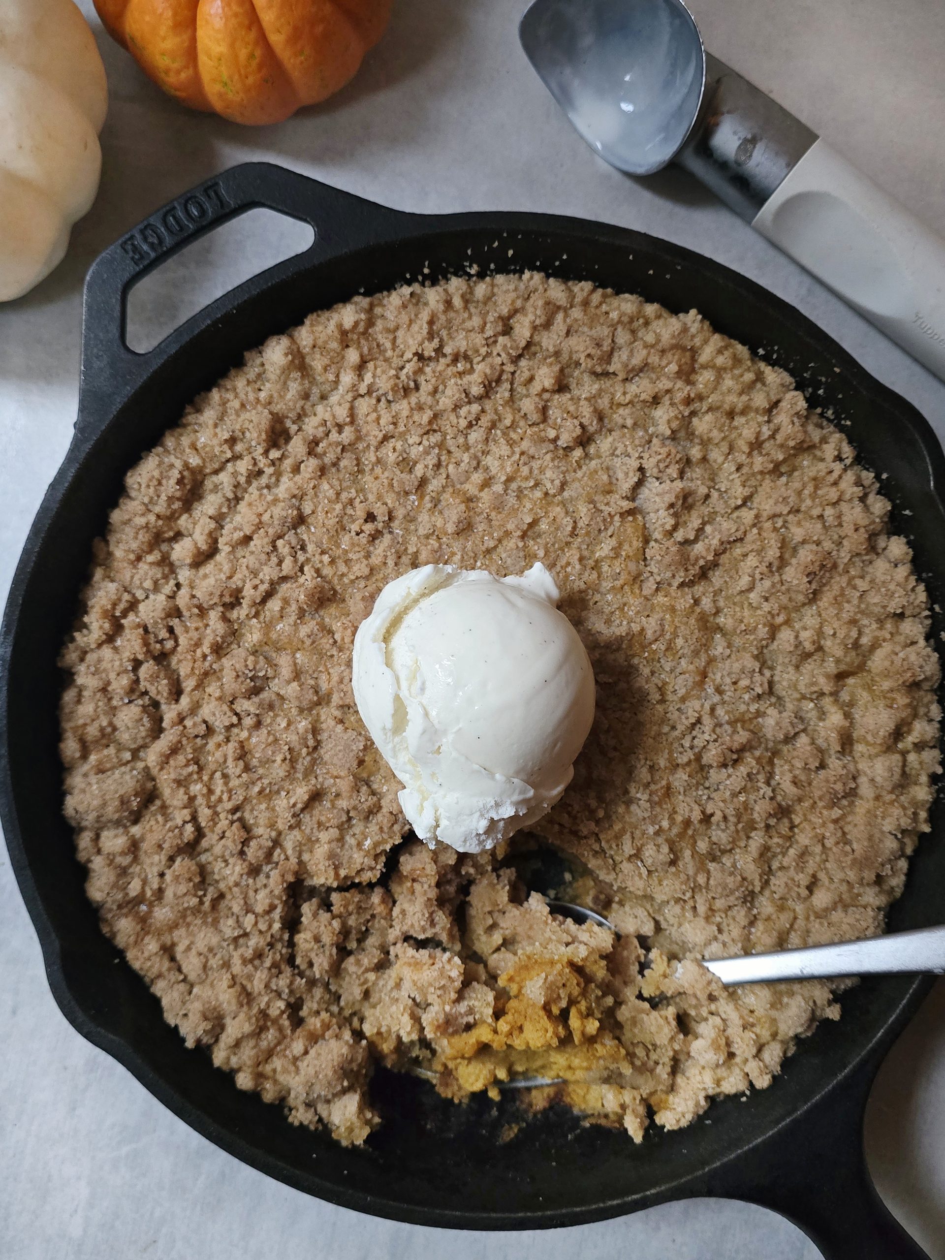 Warm gluten free pumpkin crisp topped with vanilla ice cream