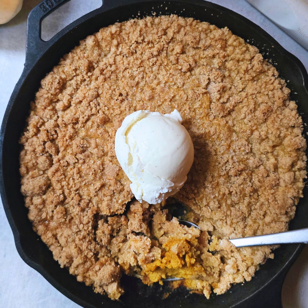 Gluten free pumpkin crisp with creamy pumpkin filling and golden oat topping served in a baking dish